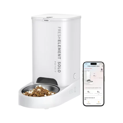 Šioje nuotraukoje matomas „Petkit Fresh Element Solo Smart Pet Feeder“. Tai yra automatinis gyvūnų ėdalo dozatorius, skirtas šerti kates ir mažus šunis. Jis yra baltos spalvos, cilindro formos su juodu ėdalo dubeniu apačioje. Ant dozatoriaus vertikaliai užrašytas prekės ženklas „FRESH ELEMENT SOLO“ ir mažesniu šriftu „PETKIT“. Šalia dozatoriaus matomas išmanusis telefonas, kuriame atidaryta „Petkit“ programėlė. Programėlės ekrane taip pat vaizduojamas „Fresh Element Solo“ dozatorius ir su juo susijusi informacija, tokia kaip nustatyti šėrimo laikai ir kiekiai. Fonas yra vientisos pilkos spalvos.