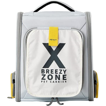 Šioje nuotraukoje matoma „Petkit Breezy Zone“ gyvūnų transportavimo kuprinė. Ji yra šviesiai pilkos spalvos su pilkais kraštais ir geltonais akcentais. Kuprinės priekyje yra didelė balta kišenė su juodu stilizuotu „X“ formos logotipu ir užrašu „BREEZY ZONE PET CARRIER“ po juo. Viršuje, centre, yra geltona etiketė su juodu užrašu „PETKIT“. Kuprinė turi juodą rankeną viršuje ir dvi reguliuojamas petnešas nugaroje (nematomos šioje perspektyvoje). Priekinės kišenės apačioje matomi du juodi raišteliai. Šonuose yra kišenės su geltonais užtrauktukais. Kuprinė atrodo tvirta ir patogi gyvūnui transportuoti.